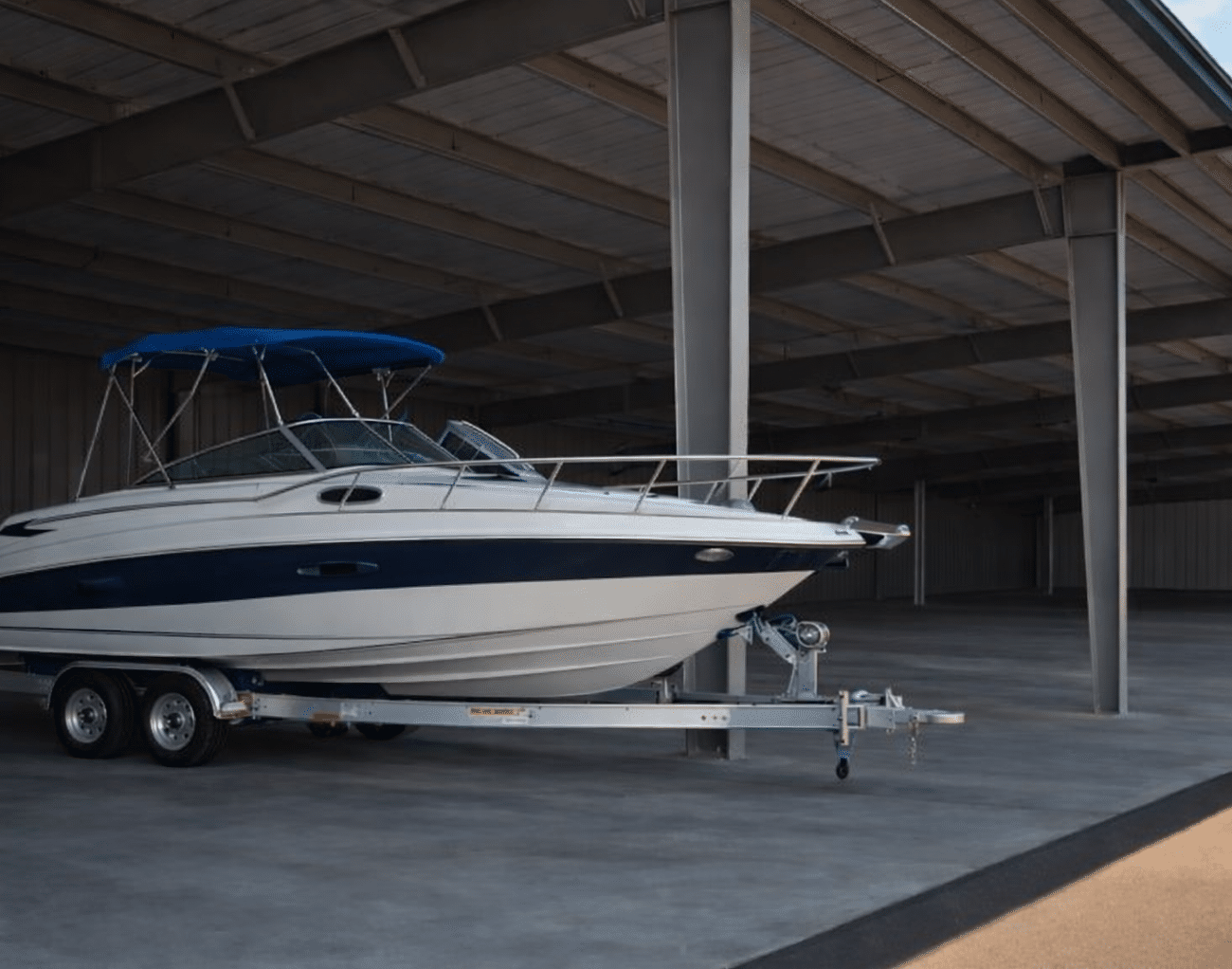 A photo of a smaller boat under outdoor cover in storage