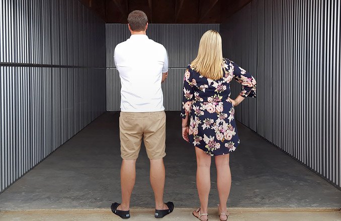 Two people looking at an empty storage unit.